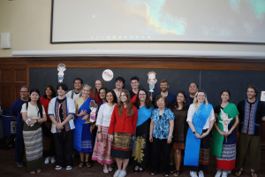 A group of people stands together and smiles at the camera