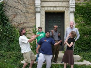 Six students smiling and pointing